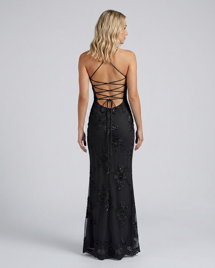 Female model in a long floral appliqué dress with a sculpted bodice and elegant shape.