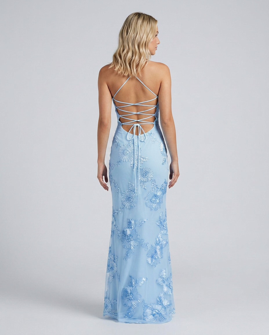 Female model in a fitted occasion dress with floral embellishments and a lace-up back detail.