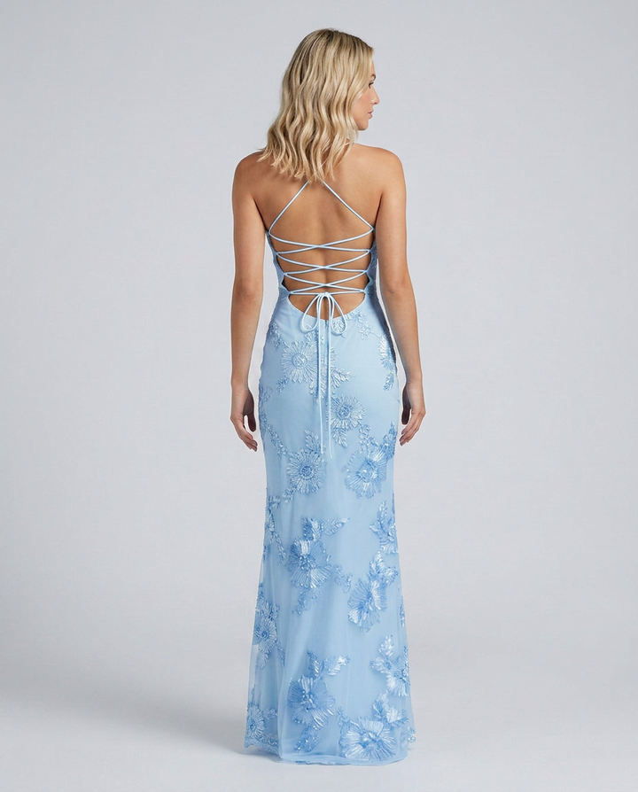 Female model in a fitted occasion dress with floral embellishments and a lace-up back detail.