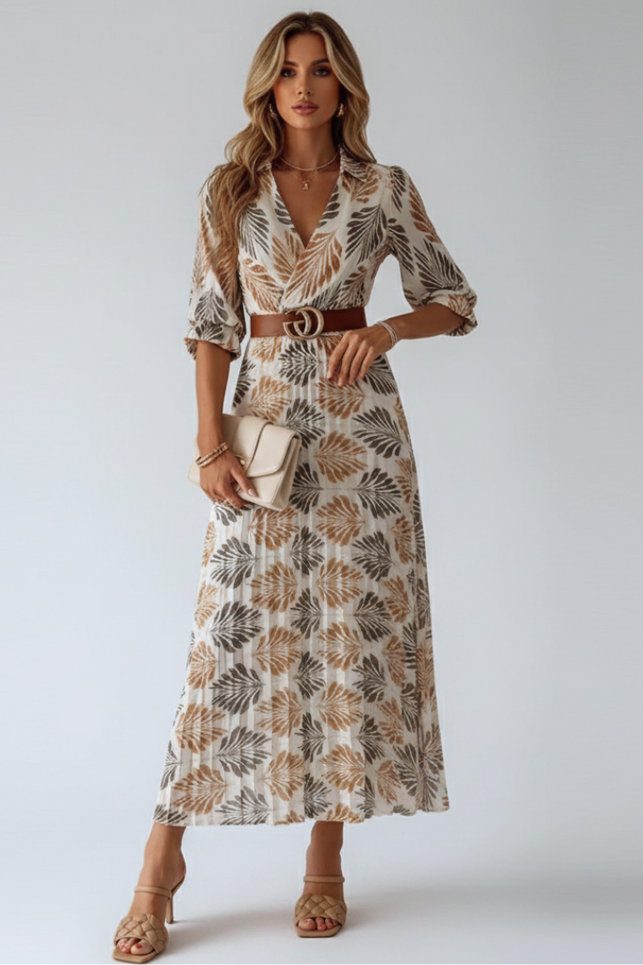 Woman wearing patterned maxi dress front view on plain gray background.
