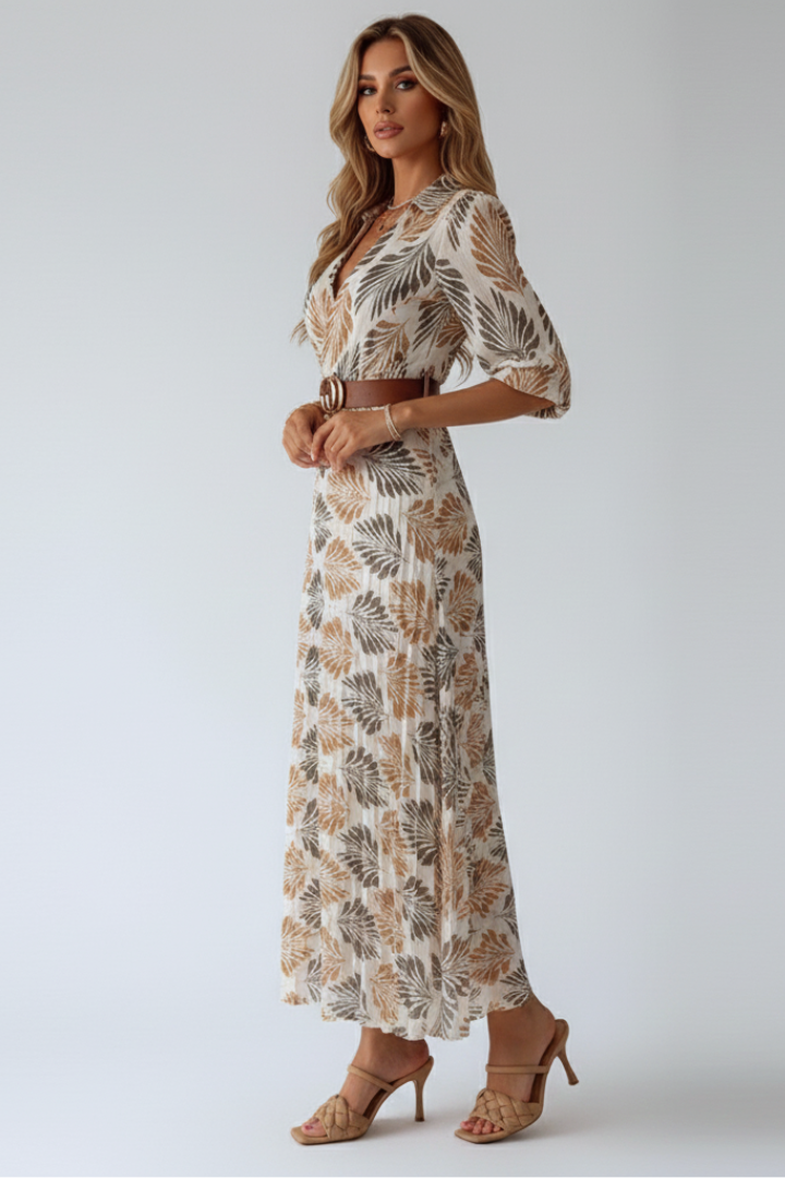 Woman showing full-length patterned dress with relaxed fit, gray background.