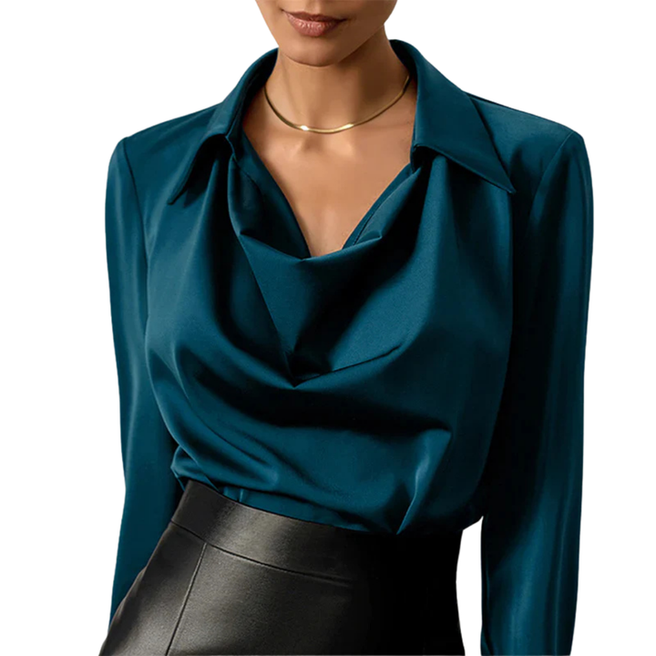 Female model wearing a modern long sleeve satin blouse on a plain background.