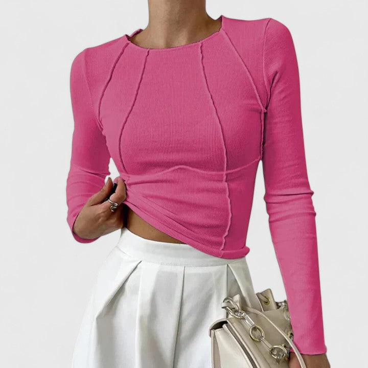 Female model showcasing a versatile women’s top on a plain background.