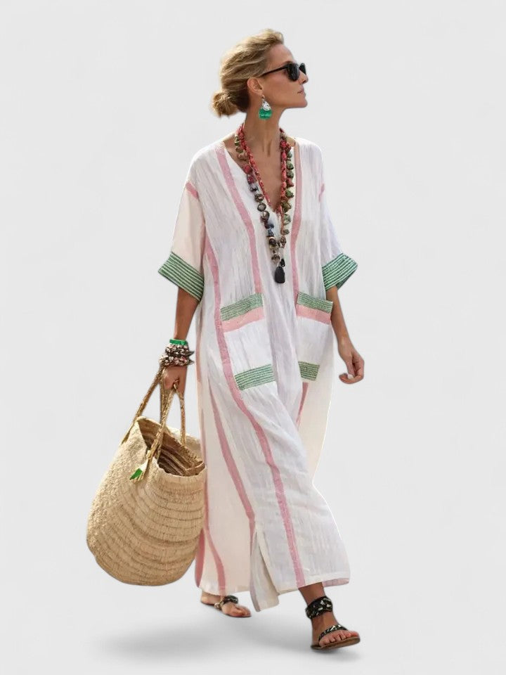 Woman wearing a striped kaftan maxi dress on a clean background.