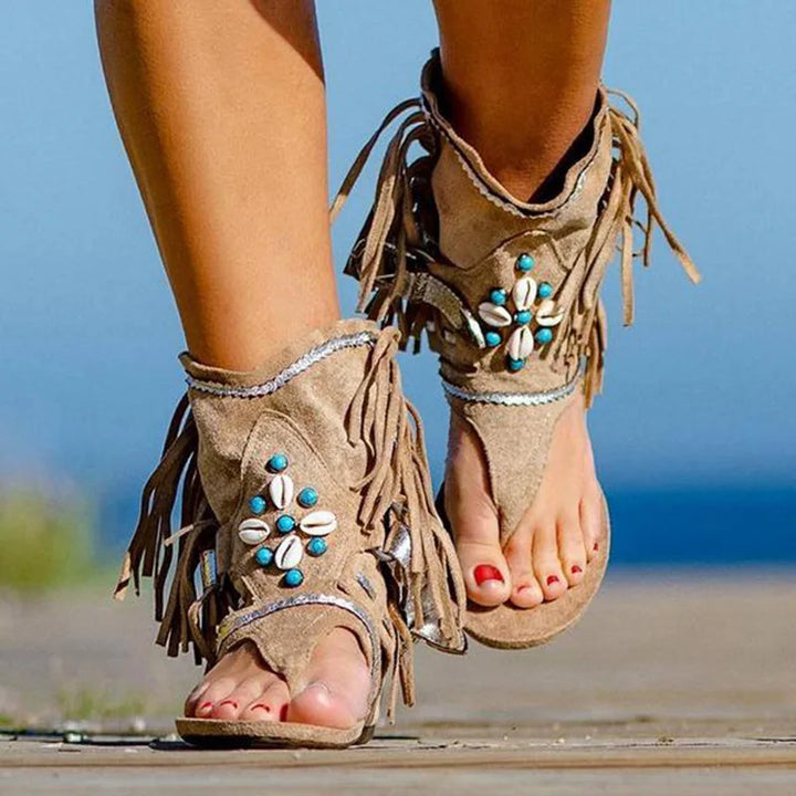 Front view of foot in beaded sandals plain background