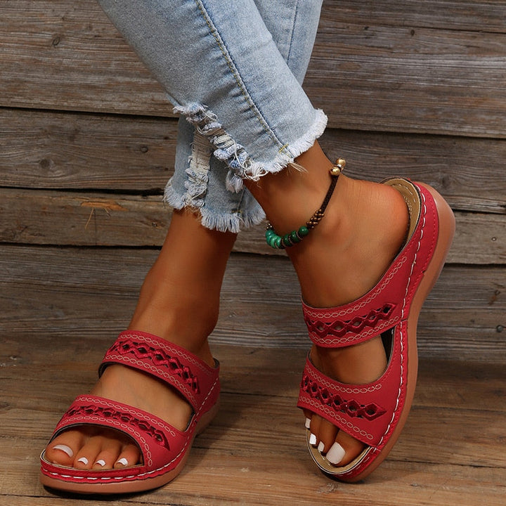 Front view sandals worn by model on gray wooden background