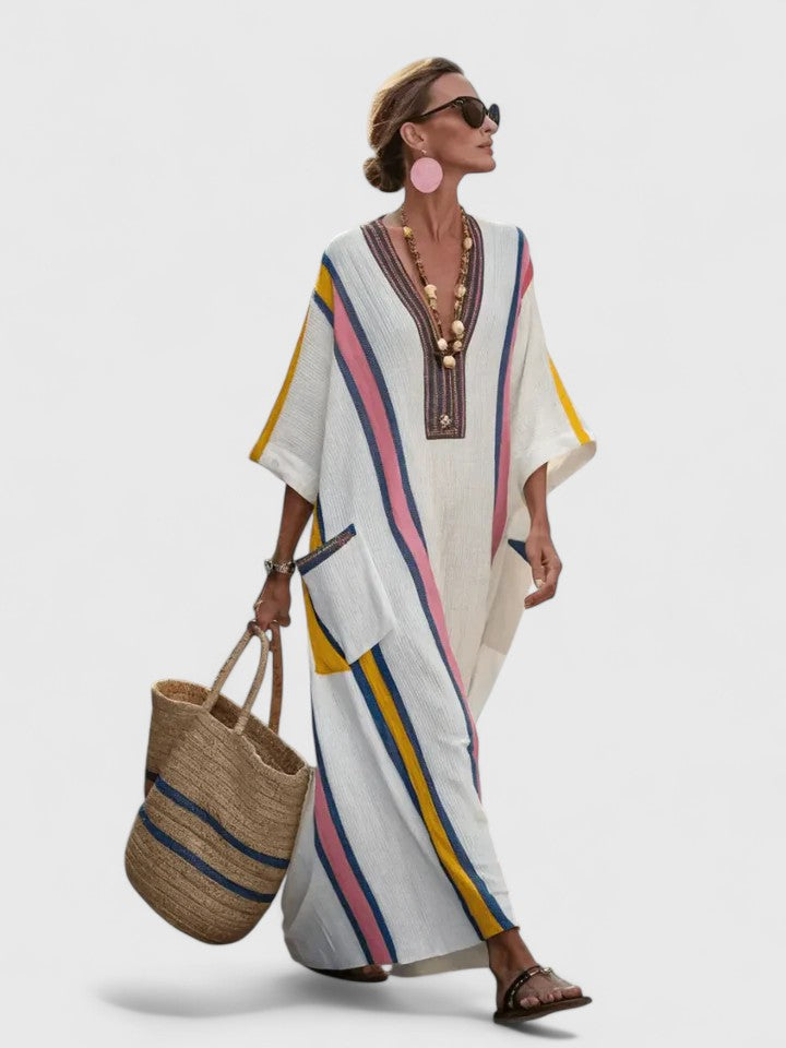 Female wearing a cream striped kaftan dress with 3/4 sleeves on a clean background.