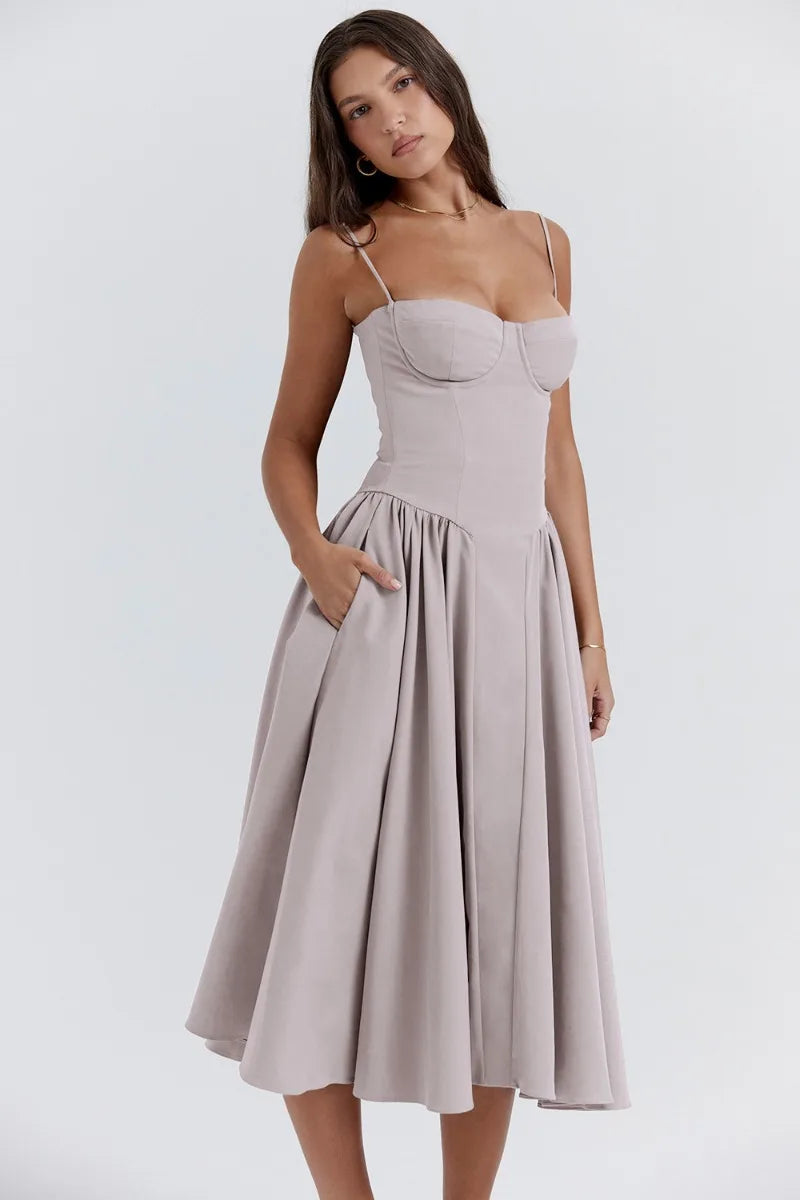 Female wearing a relaxed flowing dress on a plain background