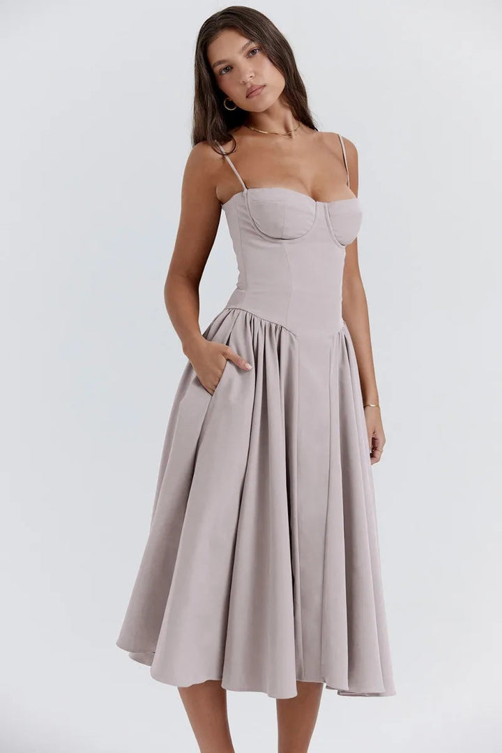 Female wearing a relaxed flowing dress on a plain background