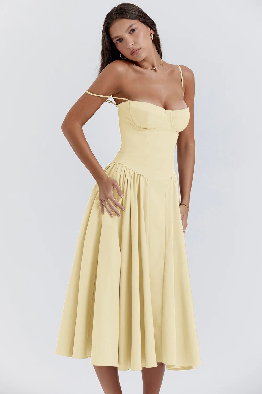 Female showcasing a flowy sleeveless outfit against a plain background