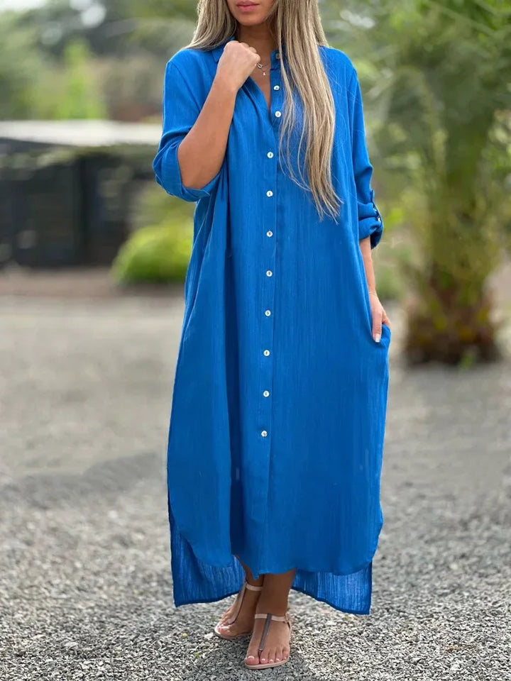 Female model posing in a casual maxi shirt dress with a simple clean backdrop.