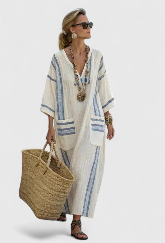 Woman styled in a relaxed V-neck striped maxi dress on a plain background.