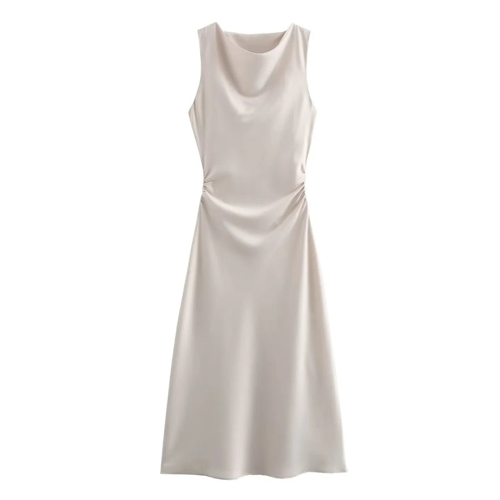 Styling a ruched midi dress on a clean backdrop.
