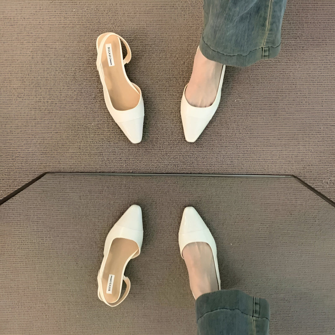 Angled top view of foot in flats plain background