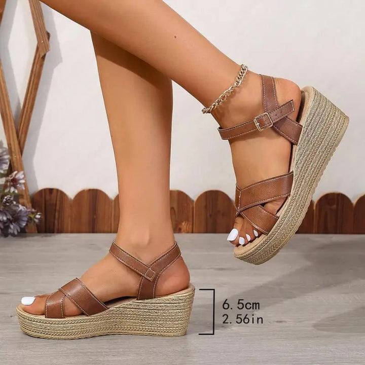 Foot model standing wearing casual wedge sandals plain background