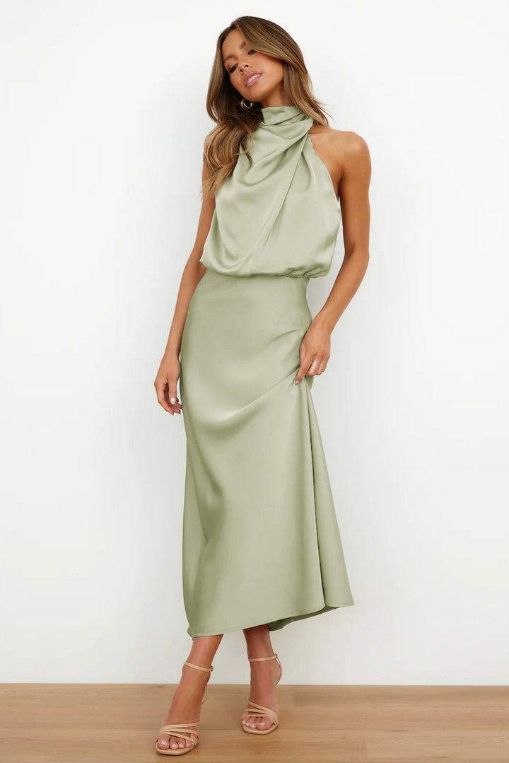  Woman posing in a sleek sleeveless formal dress on a plain background.