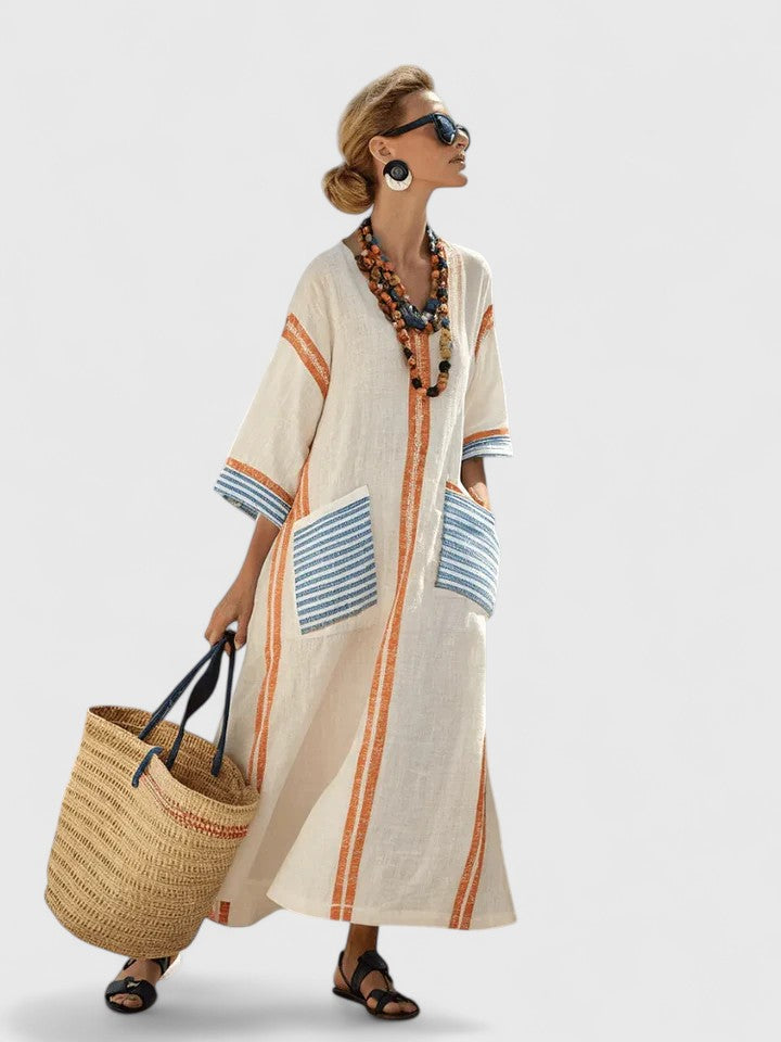 Woman wearing a loose-fit striped kaftan cover-up dress on a clean background.