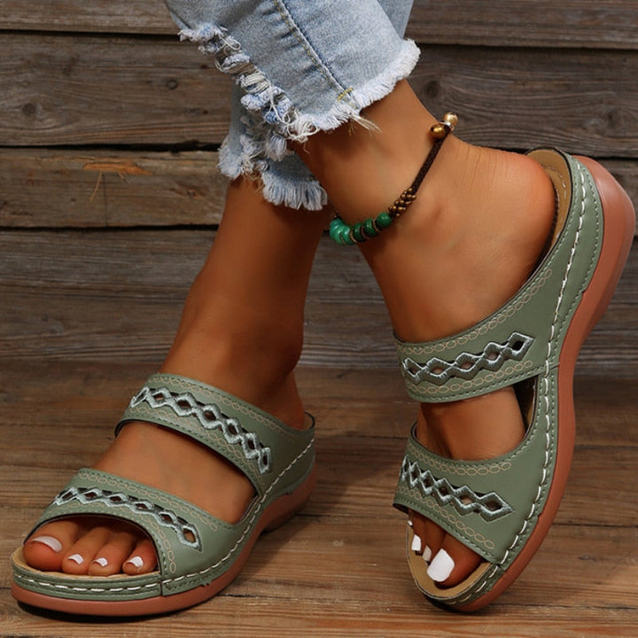 Relaxed stance showing sandals on wooden floor with foot model