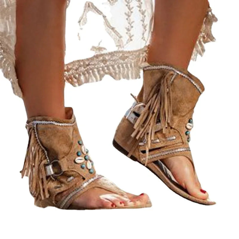Foot model standing wearing bohemian sandals plain background