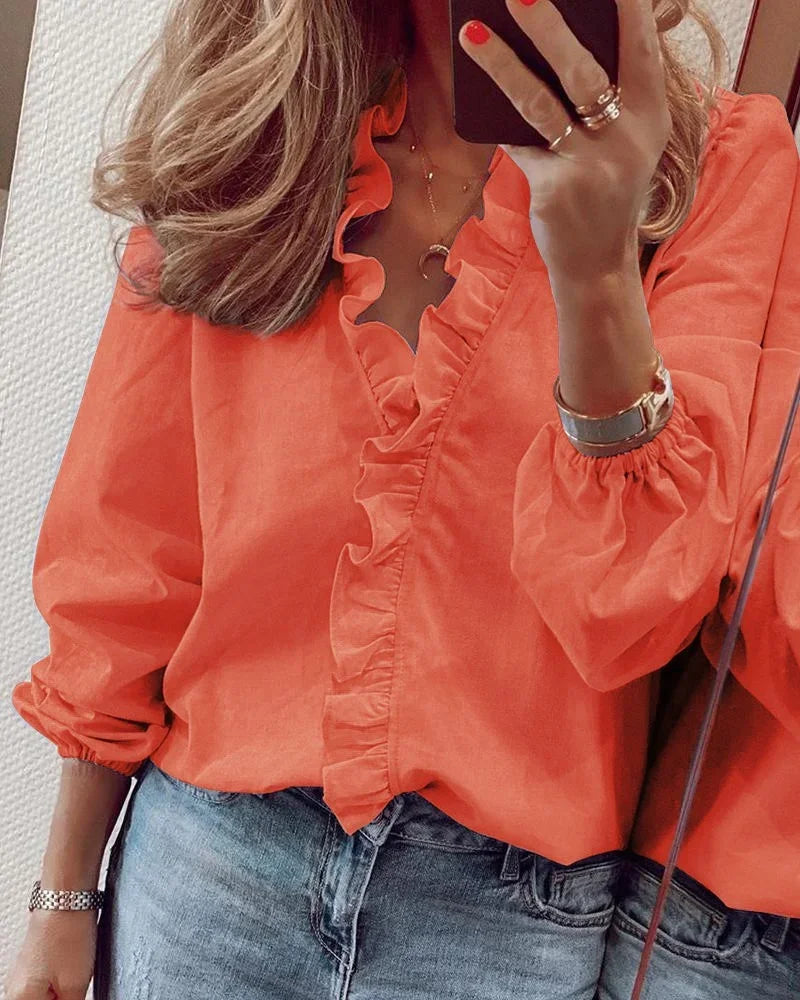 Ruffle wrap blouse on a model against a clean plain background.