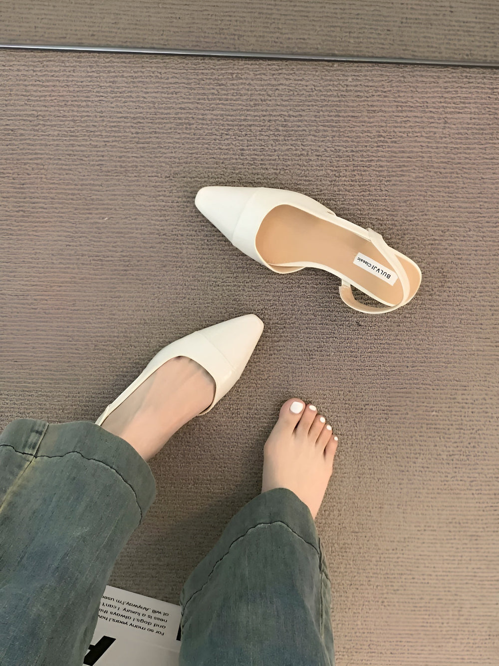 Foot model posing to highlight toe shape plain background