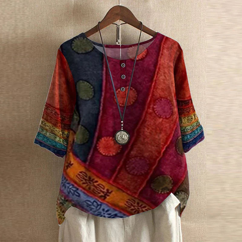 Boho style blouse hanging against neutral background