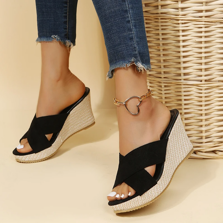 Woman standing in casual strap sandals on a plain background.