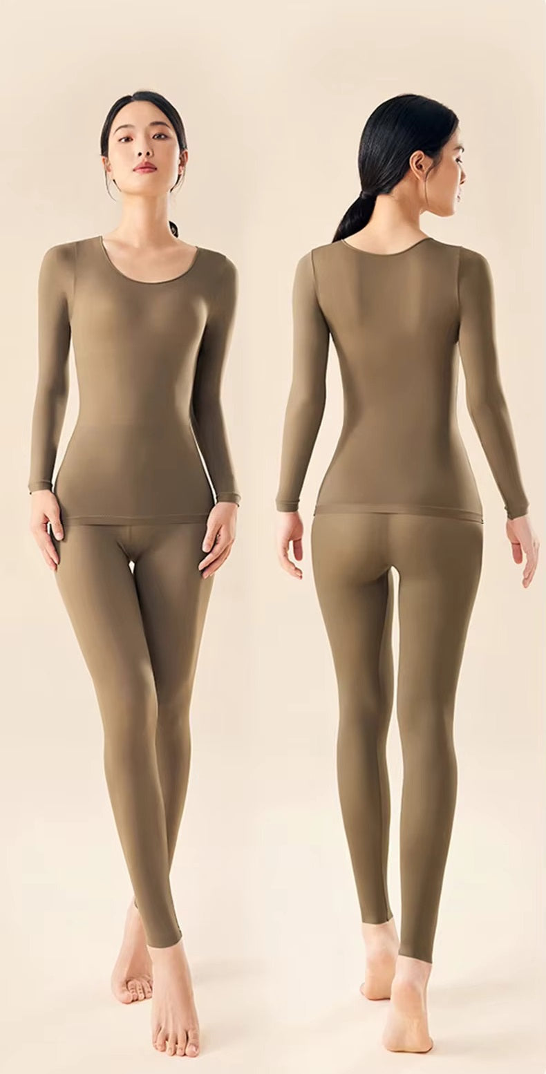 Female model showing a fitted cold weather base layer set on a plain background.