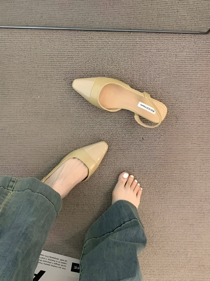 Foot model step forward pose showing flats plain background