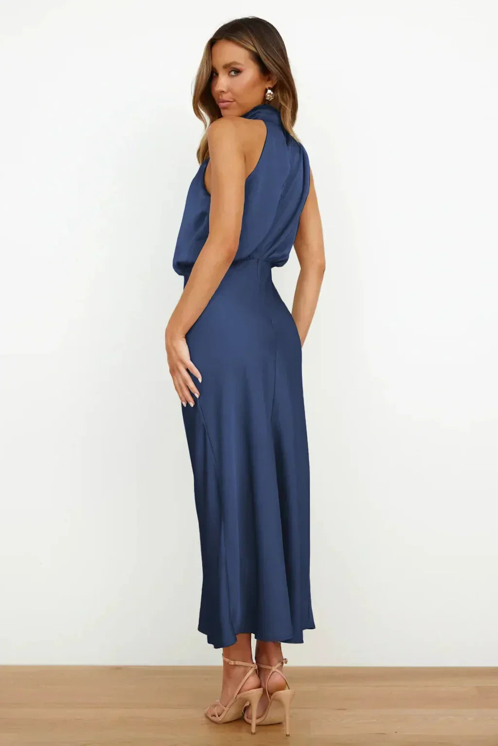 Female wearing a sleek and graceful gown with a modern silhouette on a plain background