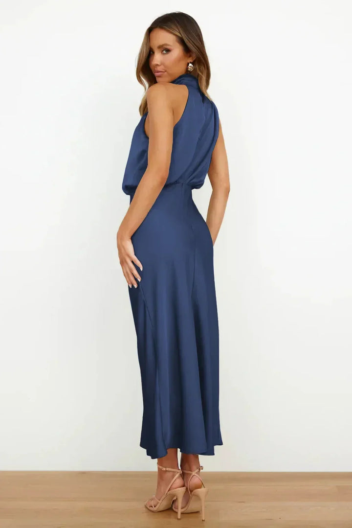 Female wearing a sleek and graceful gown with a modern silhouette on a plain background