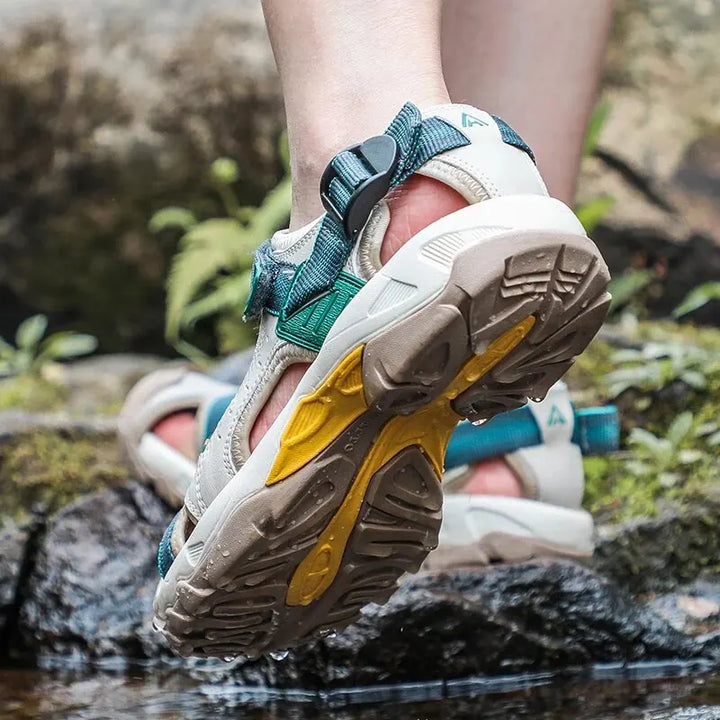 Model wearing lightweight walking shoes on a plain background with a polished casual look.