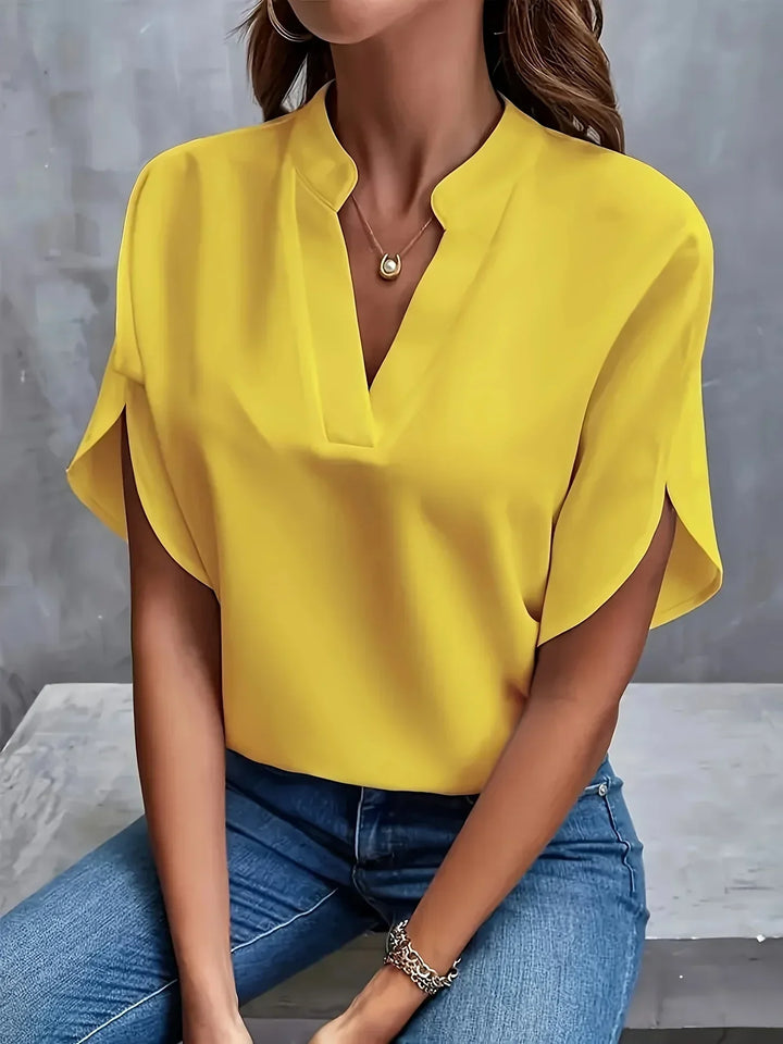 Woman model wearing a lightweight summer blouse with a relaxed fit on a plain background.