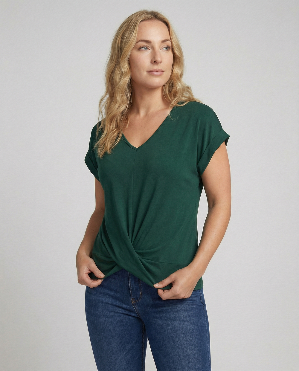 Woman showcasing a lightweight V-neck blouse with short sleeves on a plain backdrop.