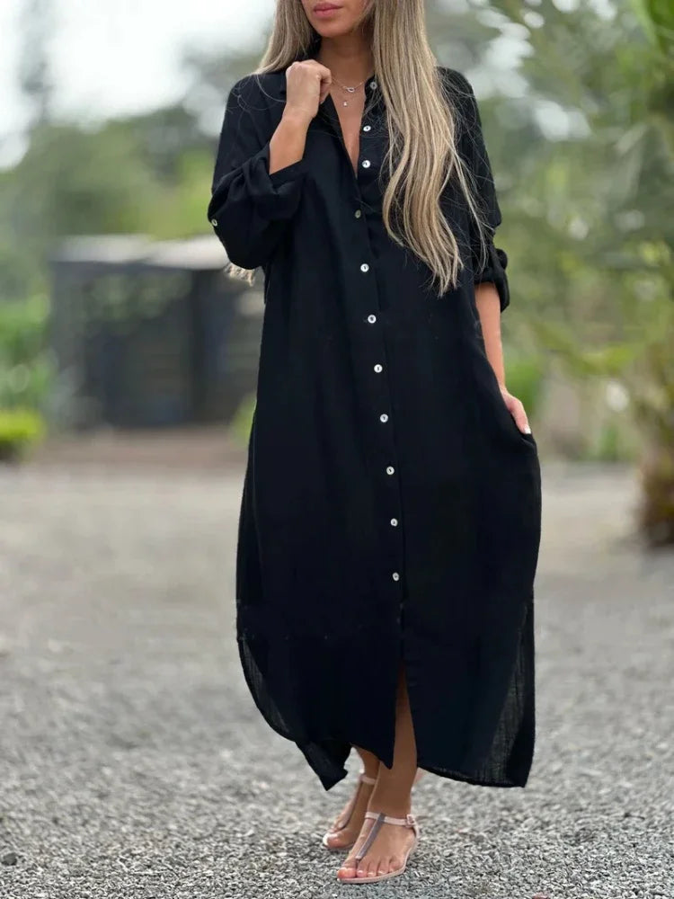 Model in a collared maxi shirt dress with full-length sleeves on a clean setting.