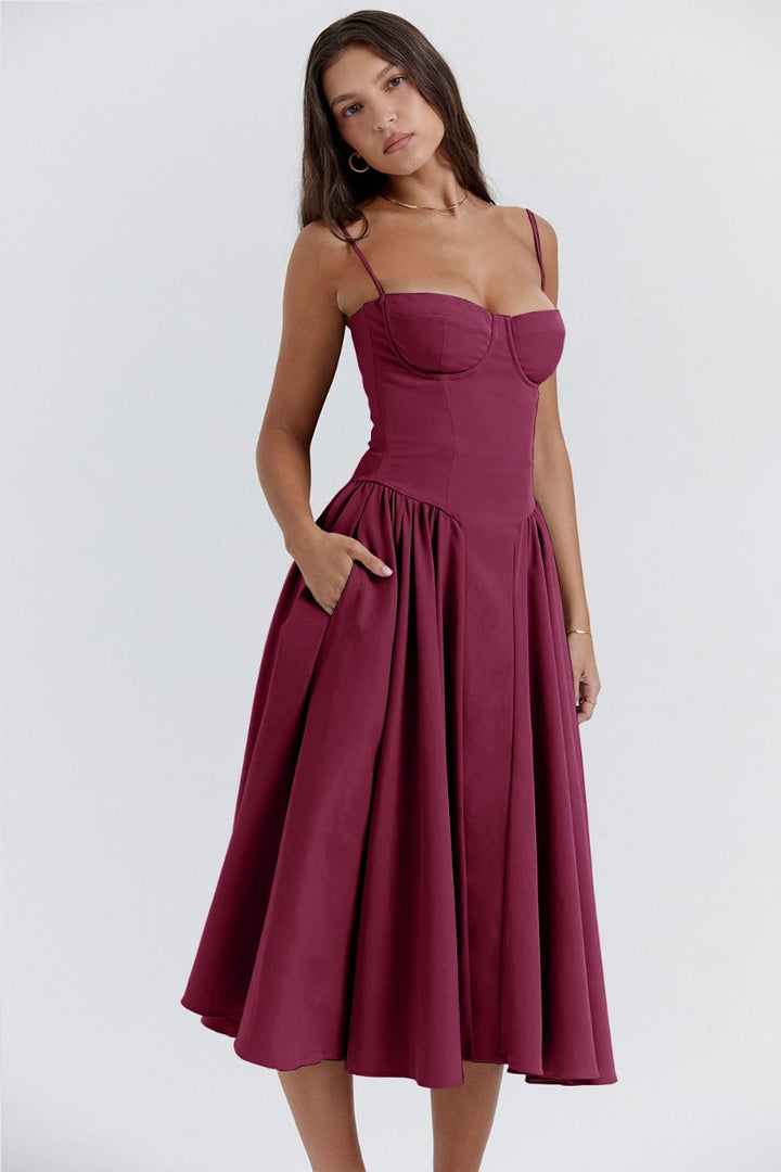 Woman showcasing a flattering waistline dress on a plain background