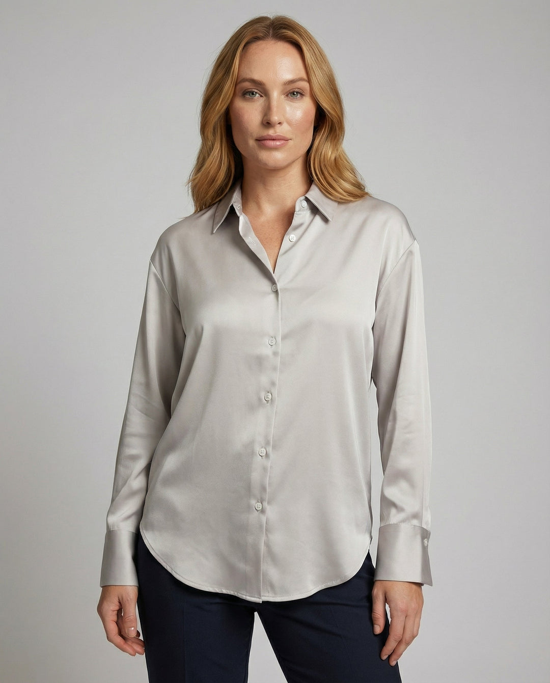 Woman wearing a vintage-style silk blouse on a plain background.