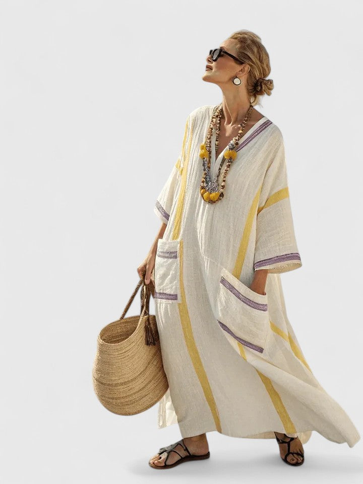 Female wearing a cream maxi dress with bold stripe panels on a clean background.