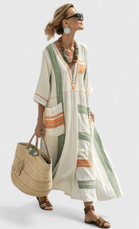Woman styled in a breezy striped kaftan dress on a plain background.