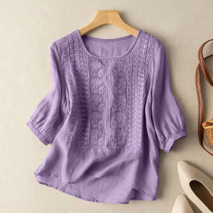 Round neck embroidered blouse displayed on a clean studio background.