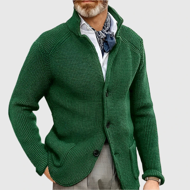 Man wearing a relaxed linen blazer and coordinated trousers on a plain background.