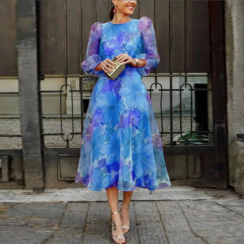 Woman in a floral midi dress featuring a flowing skirt and elegant silhouette on a plain background.