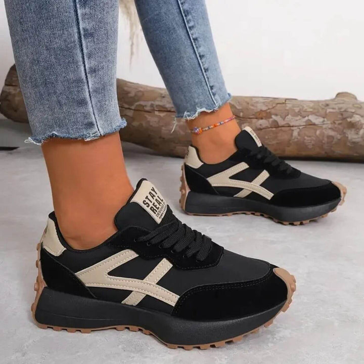 Black running sneakers with beige side stripe detail