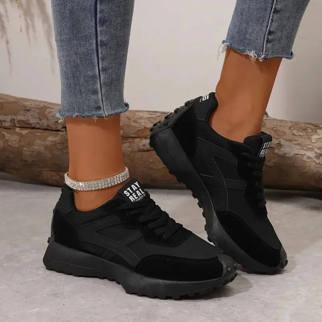 Angled view black sneakers with thick tread soles