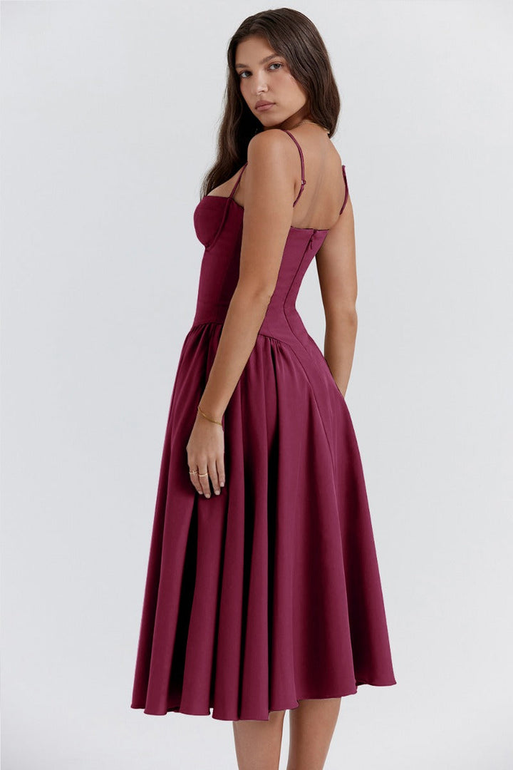 Female model in a sleeveless pleated outfit against a plain background