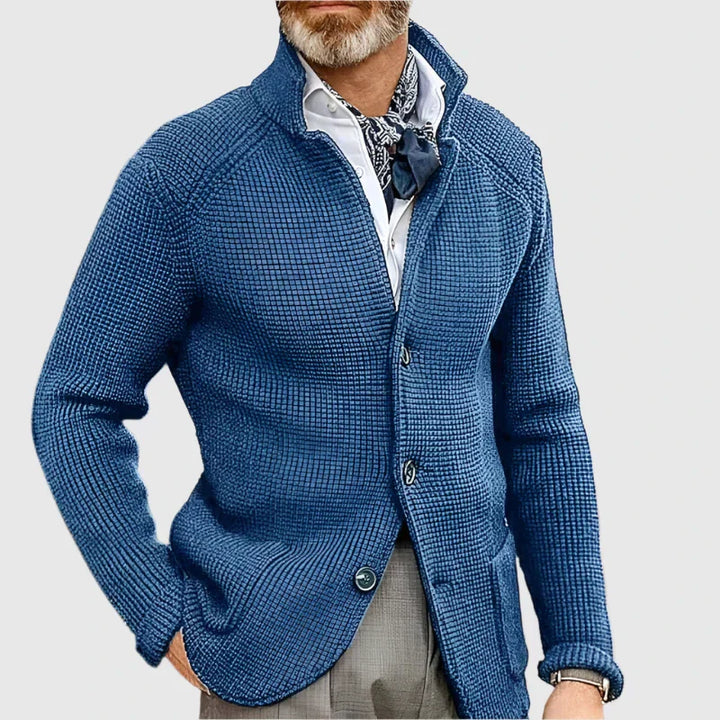 Male model wearing a light blazer with matching straight trousers on a plain background.