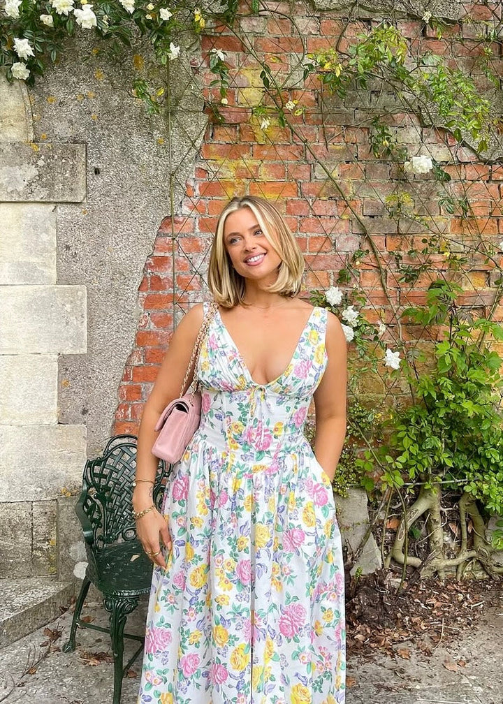 Sleeveless formal dress styled for evening occasions on a nature brick background.