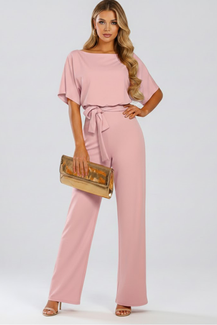 Female model wearing a short sleeve full-length jumpsuit with clean front view on a plain background.