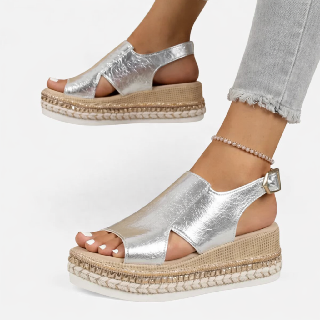 Woman model showcasing slingback wedge sandals with side cut-out details on a plain background.