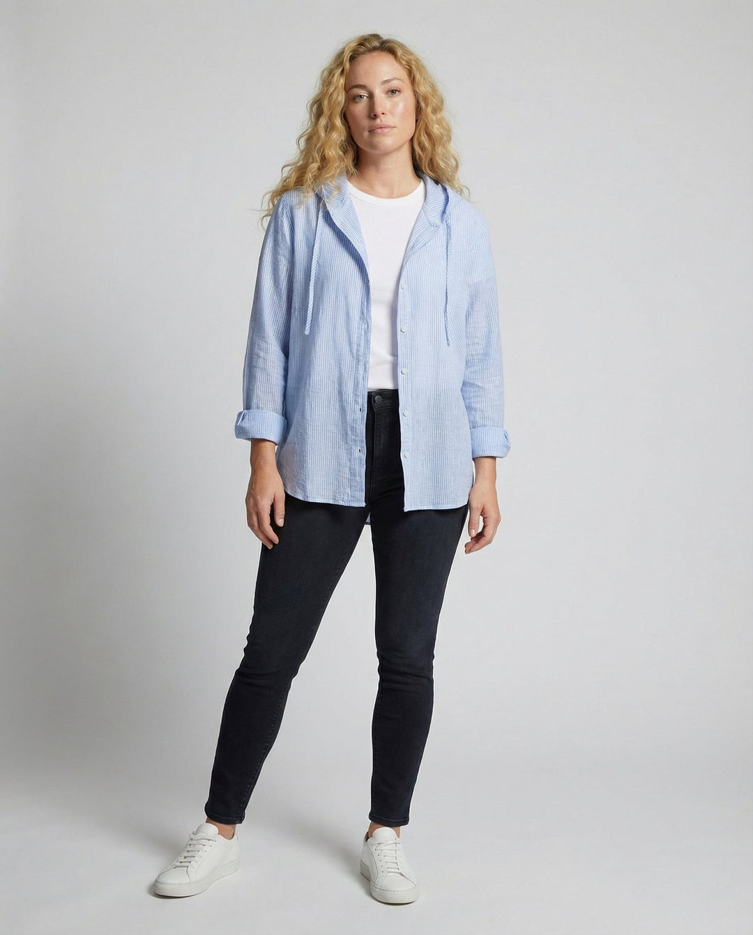 Woman showcasing a breathable long-sleeve blouse on a plain background.
